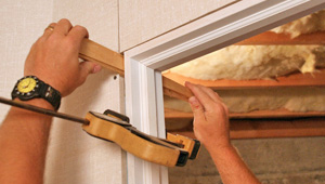 Installing trim and finishing touches to a remodeled basement in Elmira, NY