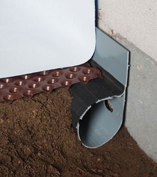 Closeup of a crawl space drainage system installed in Corning