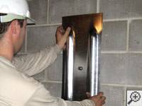 Mounting a foundation wall plate for an earth anchor installation in Penfield.