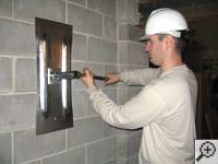 Attempting to straighten a bowed foundation wall by straightening a wall anchor system in a Rome home.