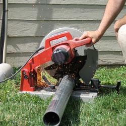 Cutting the support beam for a crawl space jack post outside a Rome home.