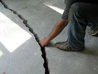 a severely damaged cracked concrete slab floor in Baldwinsville