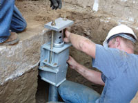 Foundation repair contractors installing the foundation bracket in Utica.