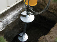 Installing a helical pier system in the earth around a foundation in Ithaca