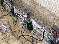 Using foundation push piers to lift a foundation during a repair in Henrietta.