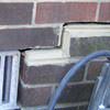 A closeup of a failed tuckpointing job where the brick cracked on a Massena home.
