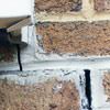 Failed crack repair showing old tuckpointing that cracked on a Utica home.