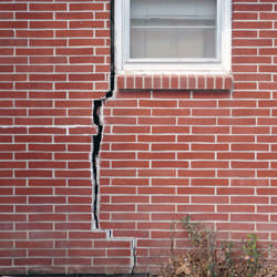 A foundation with a large crack that's wider at the top than on the bottom in Corning