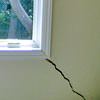 A long, diagonal crack that begins at a window corner of a Cortland home