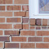 long jagged cracks starting at the corner of a window along a brick wall on a Plattsburgh home