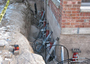 Foundation push piers installed around a house with a foundation settlement issues in Corning
