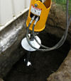 Installing a helical pier during a foundation repair in Ithaca