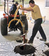Digging a hole in the garage floor to make room for a wall anchor installation in Horseheads, New York