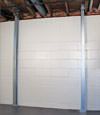 A steel i-beam system installed on a Massena foundation wall
