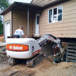 Excavating to expose the foundation walls and footings for a replacement job in Penfield