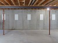 A repaired basement wall with foundation wall anchor covers installed in Elmira.