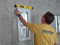 Positioning a wall plate cover on a foundation wall in Rochester.